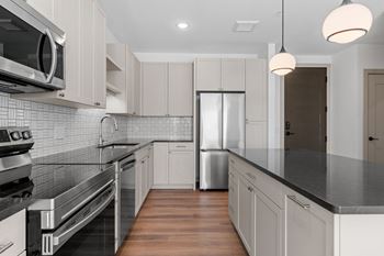 a kitchen with black counter tops and white cabinets